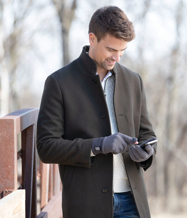 a man standing outside wearing the Pro Tip Texting Gloves while texting on his phone