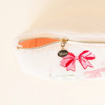 top view of bows zipper pouch with zipper partially zipped.