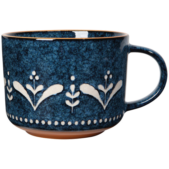 A blue ceramic mug with white floral patterns 