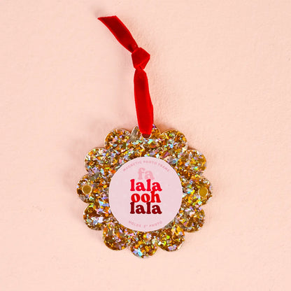 gold glitter Scalloped Acrylic Frame Ornament with red hanging ribbon show on a beige background
