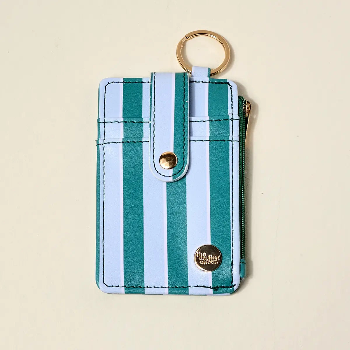 aqua Striped keychain pouch with gold ring and visible brand logo on a beige background