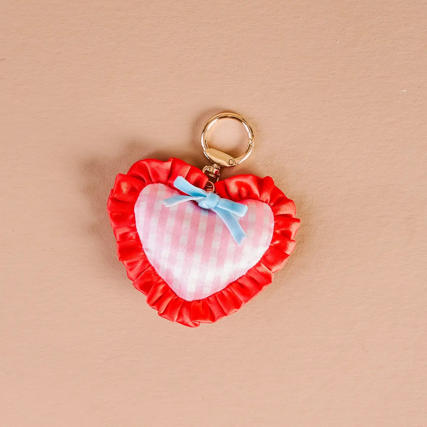 berry sweet Heart-shaped bag charm with red ruffle and pink center on a beige background