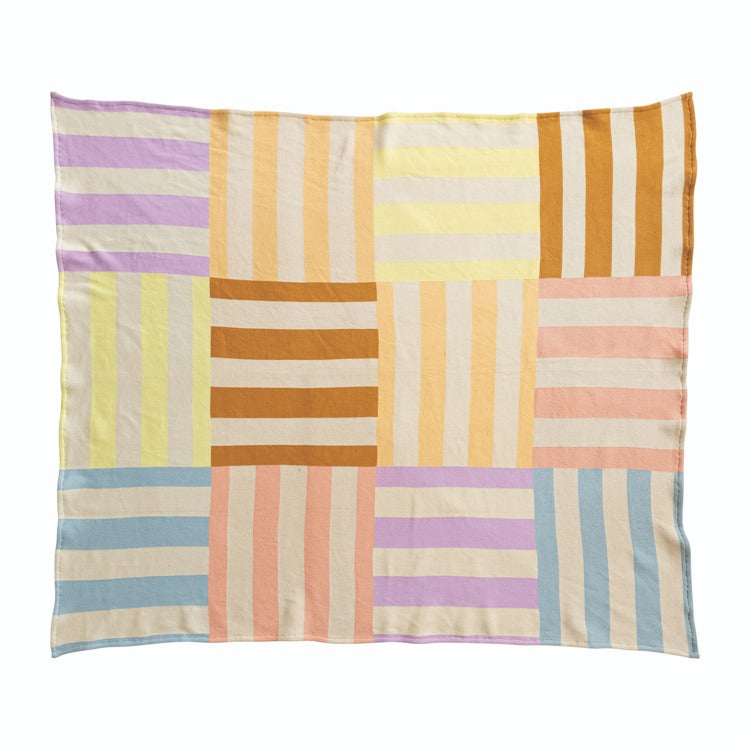 Colorful striped blanket with a patchwork design on a white background