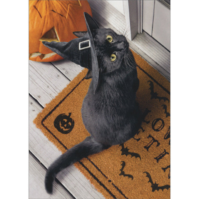 front of card is a black cat with a witch hat on sitting on a halloween doormat