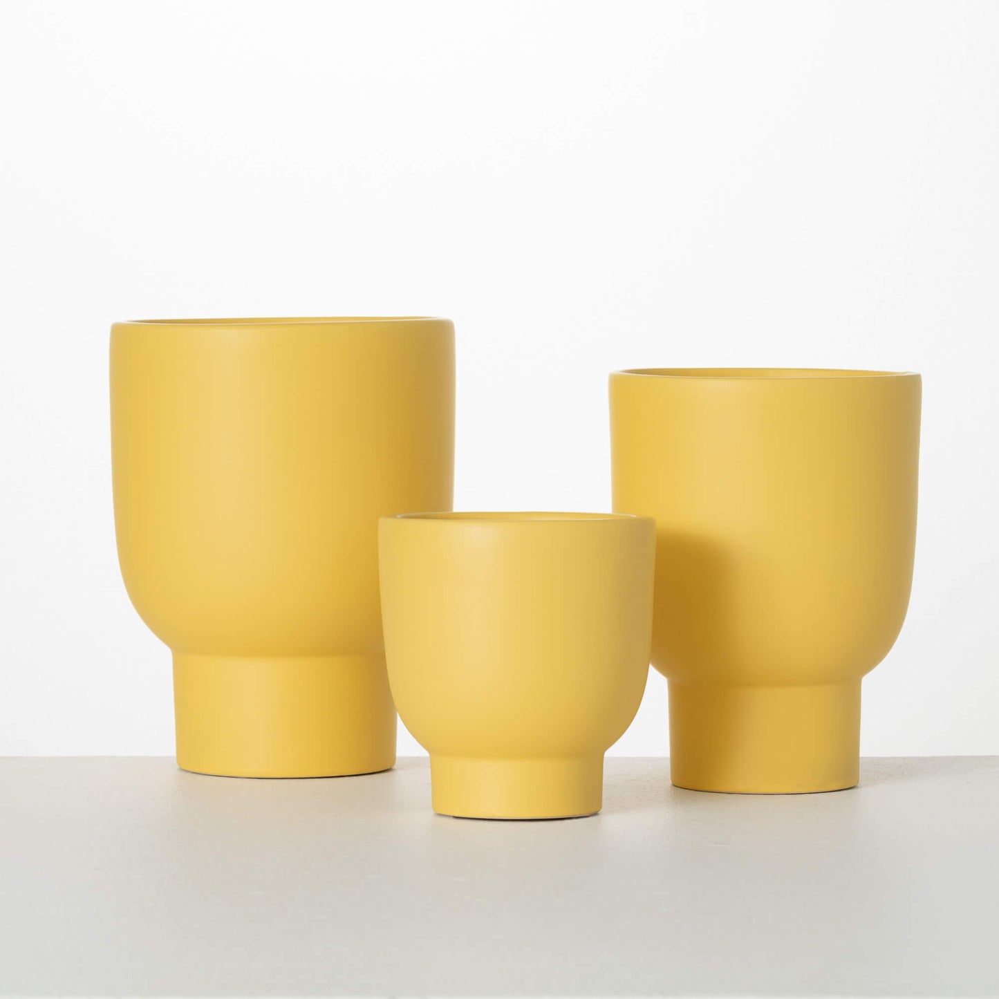 3 sizes of yellow planters on a white background.