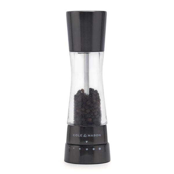 derwent pepper mill partially filled with black peppercorns.
