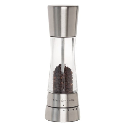 derwent stainless steel pepper grinder partially filled with peppercorns.