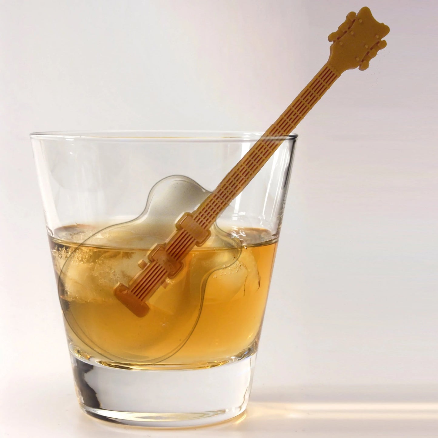 ice shaped guitar with stir stick in a beverage.