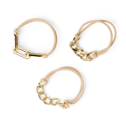 3 assorted beige hair ties with gold tone chain accents on them.