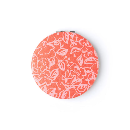 compact mirror with pink floral design.