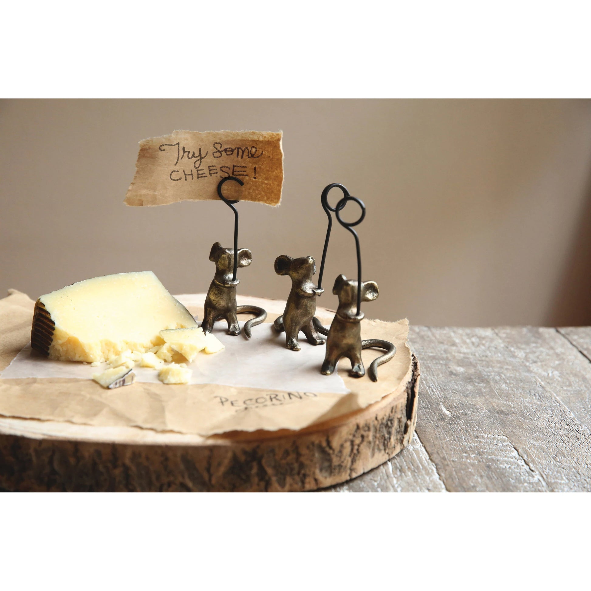 3 cast iron mice set on a wooden board with cheese, one mouse in holding a card that reads "try some cheese".