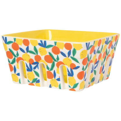 berry basket that’s yellow in the inside and the outside is covered in yellow orange citrus images