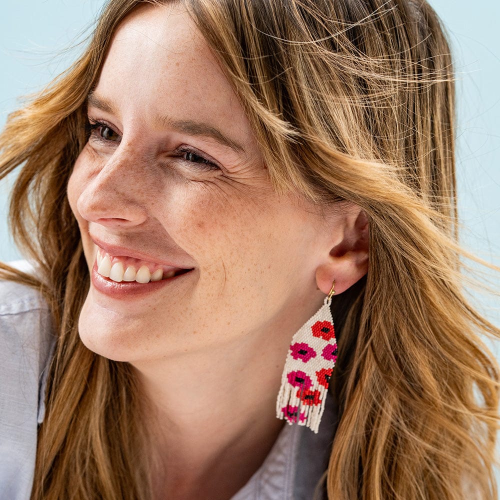 smiling person wearing Pink & Red Poppy Beaded Fringe Earrings