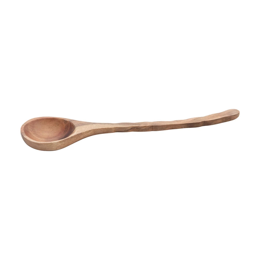 side view of wooden spoon with a slight curved handle on a white background.
