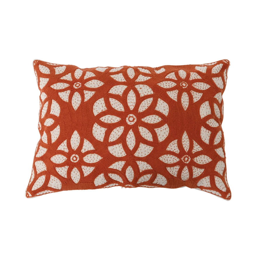 cream pillow with orange embroidery medallions in an all-over pattern.
