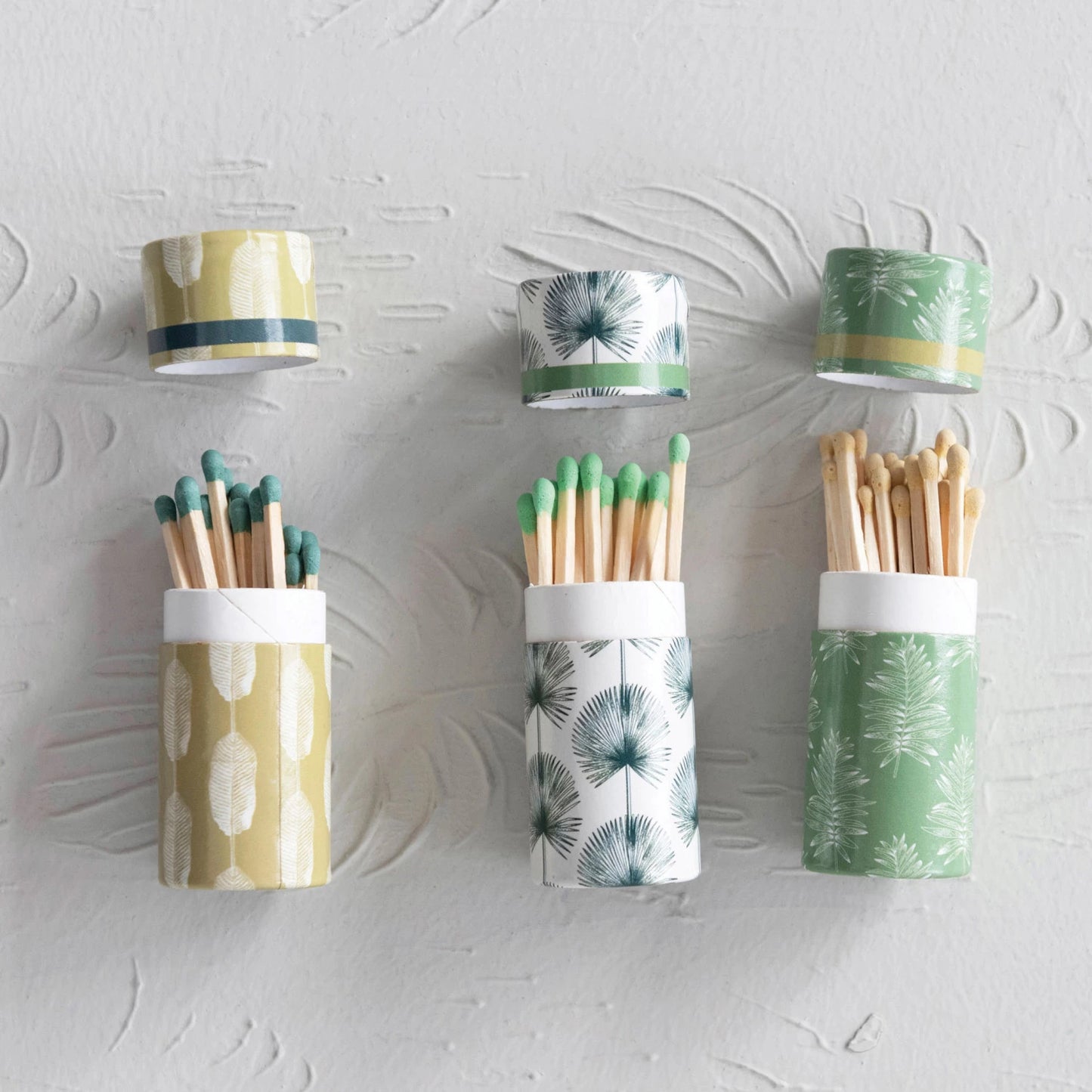 3 styles of match tubes with assorted leaf designs laying open with matches coming out of them.