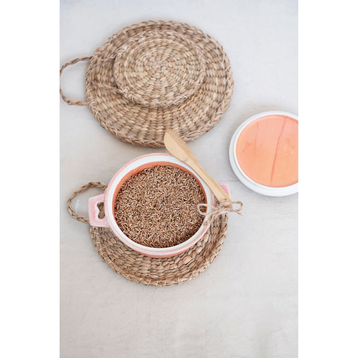 small ceramic baker filled with brown rice set on a woven tray