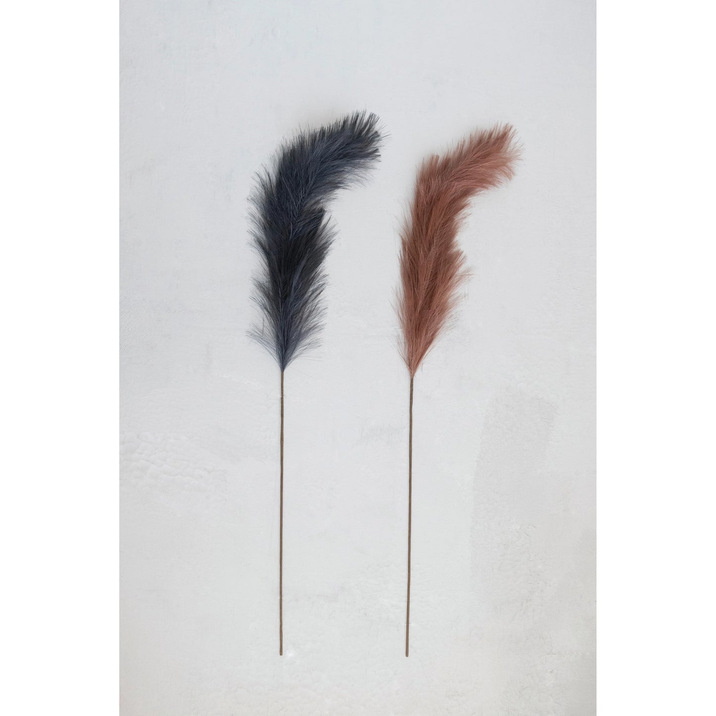 midnight and mulberry plumes laying on a plaster background.