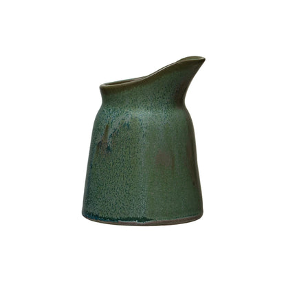 green stoneware creamer shown on a white background