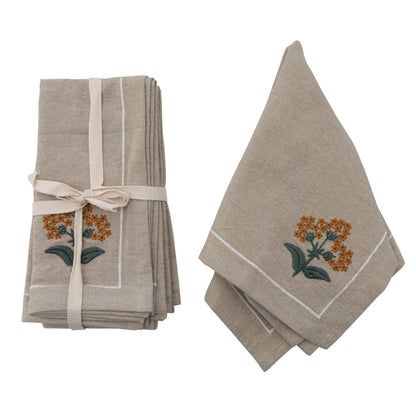 set of cotton floral napkins tied with a ribbon and another napkin draped next to it