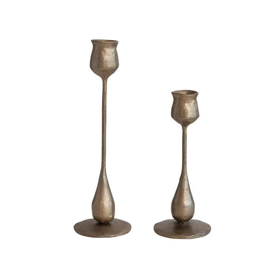 both sizes of antique brass hand forged iron taper holder displayed against a white background