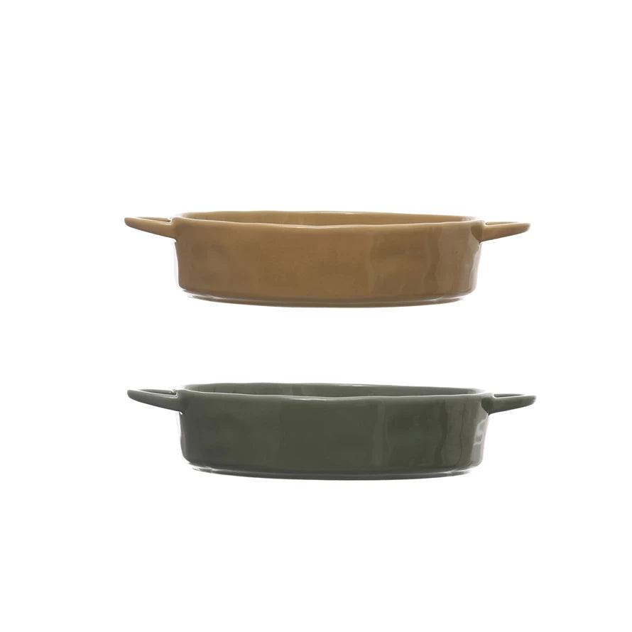 side view of both tan and gray stoneware serving baker with handles displayed against a white background