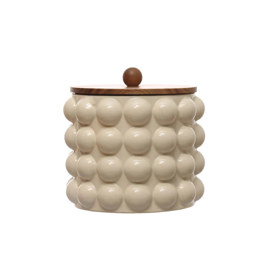 large raised dots and acacia wood lid stoneware canister displayed on a white background