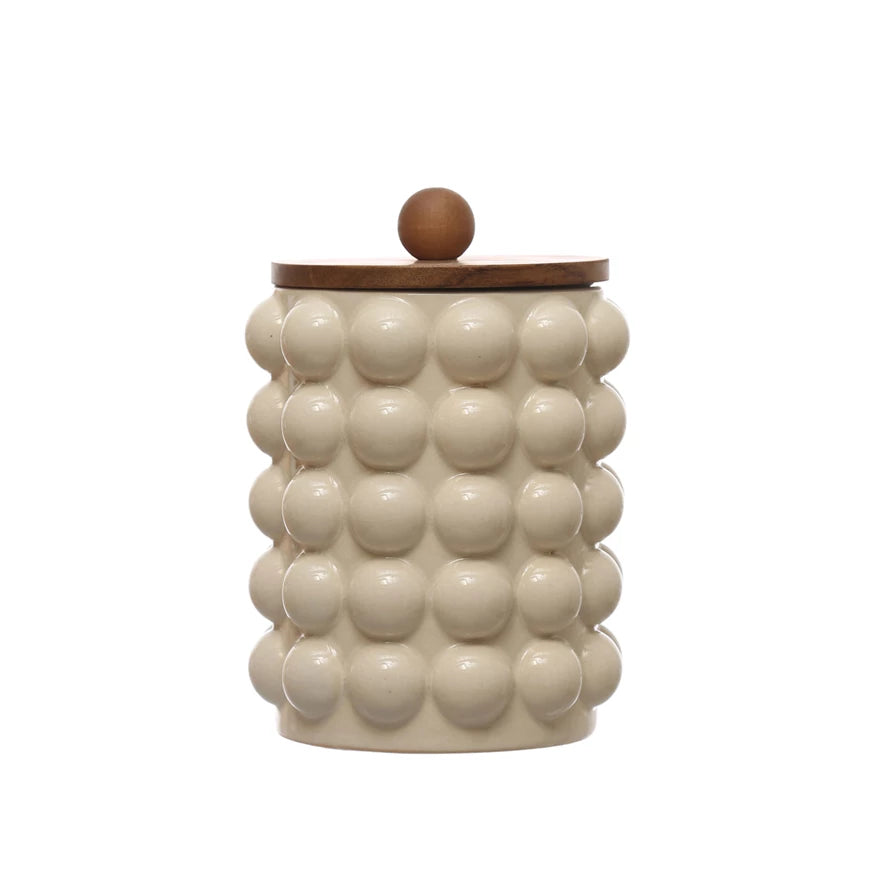 small raised dots and acacia wood lid stoneware canister displayed on a white background