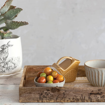 the orange bird shaped stoneware creamer displayed in a wooden tray next to berry bowl of oranges and striped bowl