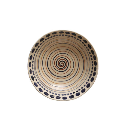 top view of cream bowl with blue dots and blue and rust colored swirled lines in the interior.