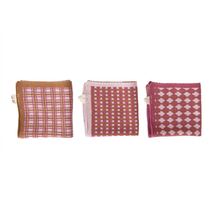 3 styles of folded pink and brown knitted cloths in a row on a white background.