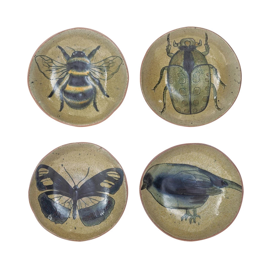 4 assorted grey-green dishes with images of either a bee, beetle, butterfly, or bird painted on them.