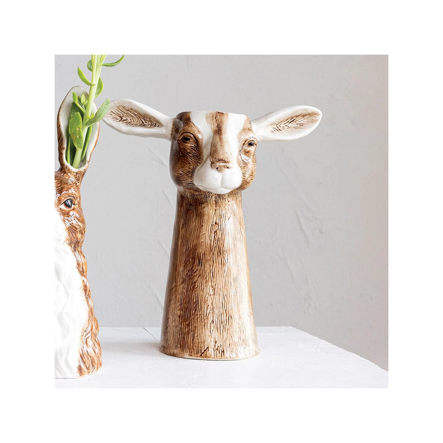 Decorative vase shaped like a goat's head on a white surface