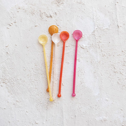 colorful spoons on a textured white surface