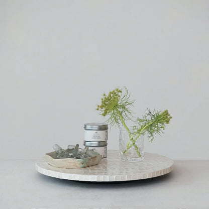 side view of Capiz Lazy Susan set on a table with dishes and greenery on it