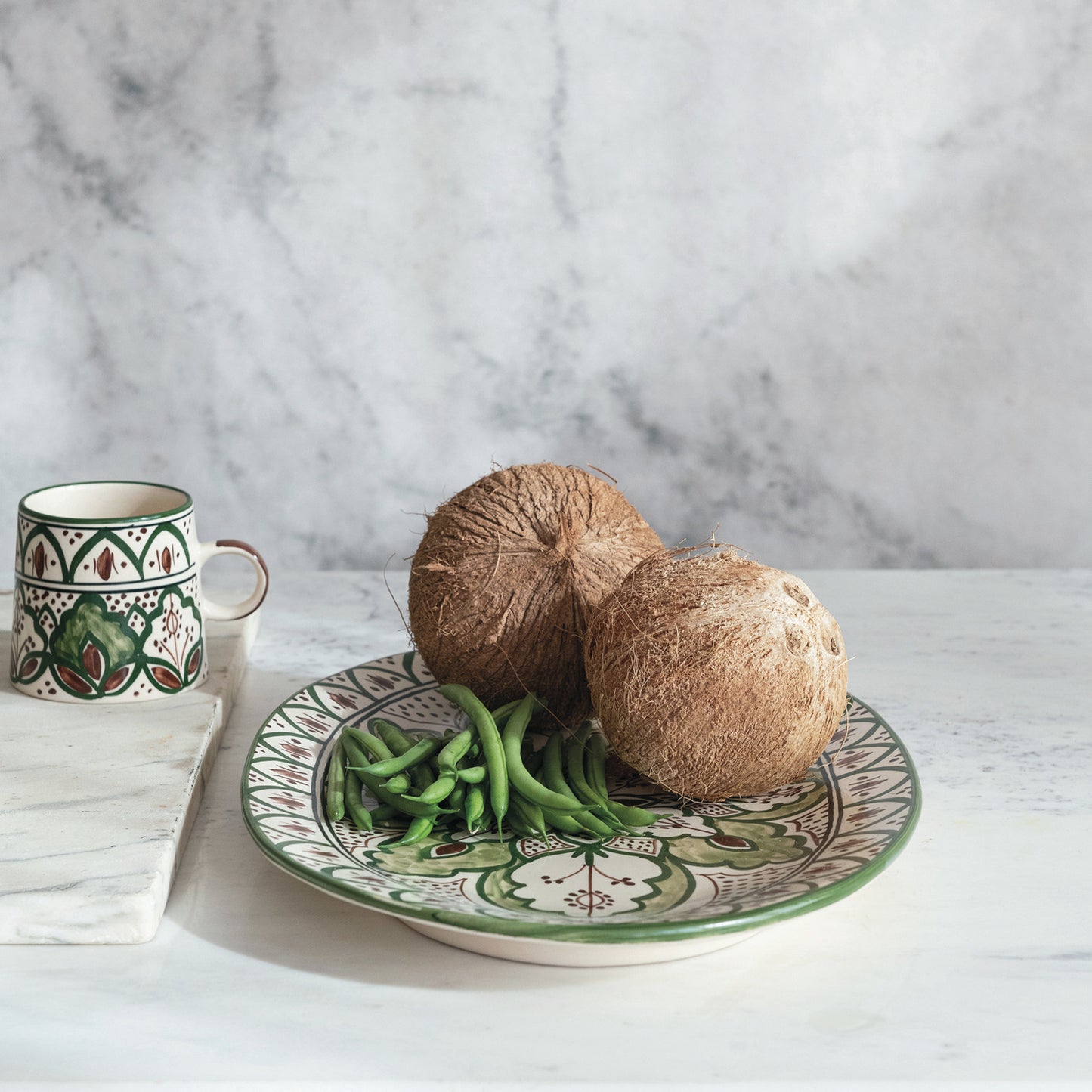 botanical platter set on a table with green beans and coconuts on it.