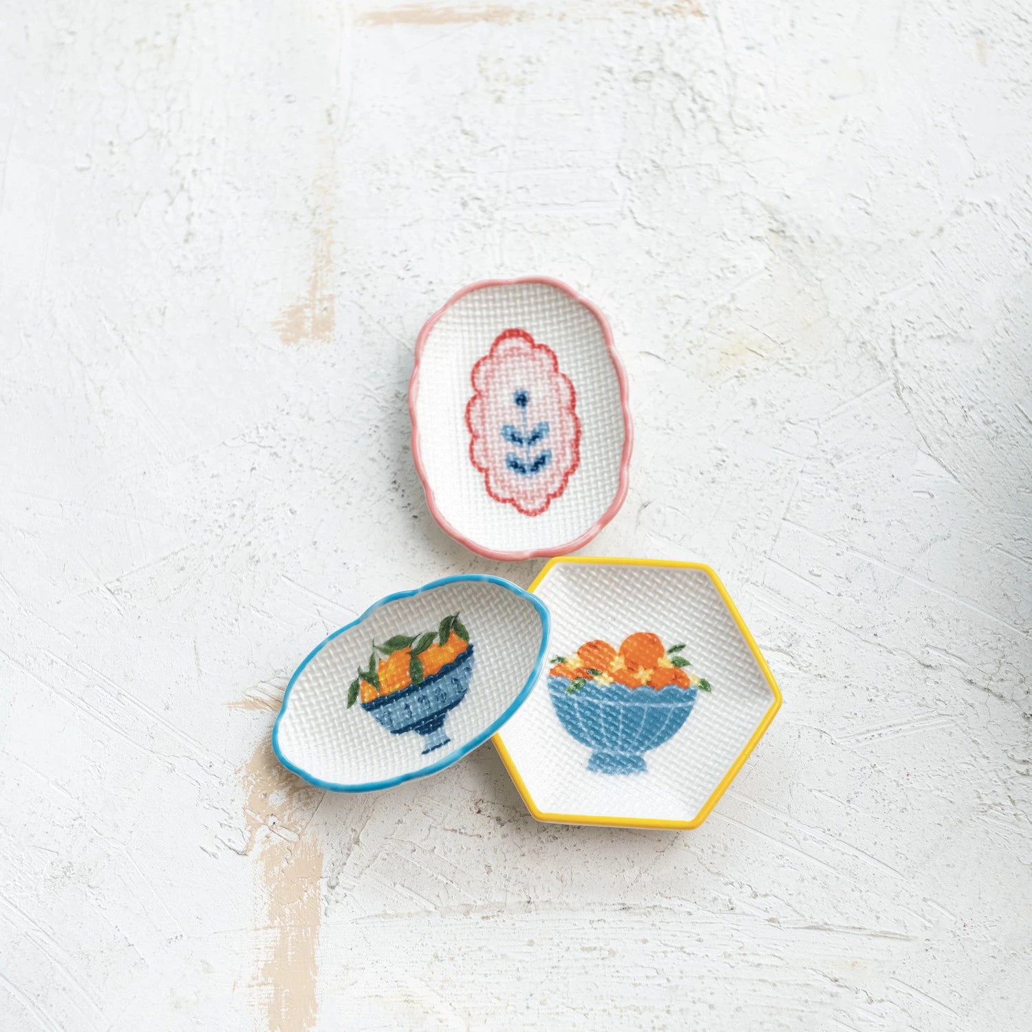3 styles of little dishes arranged on a plaster surface