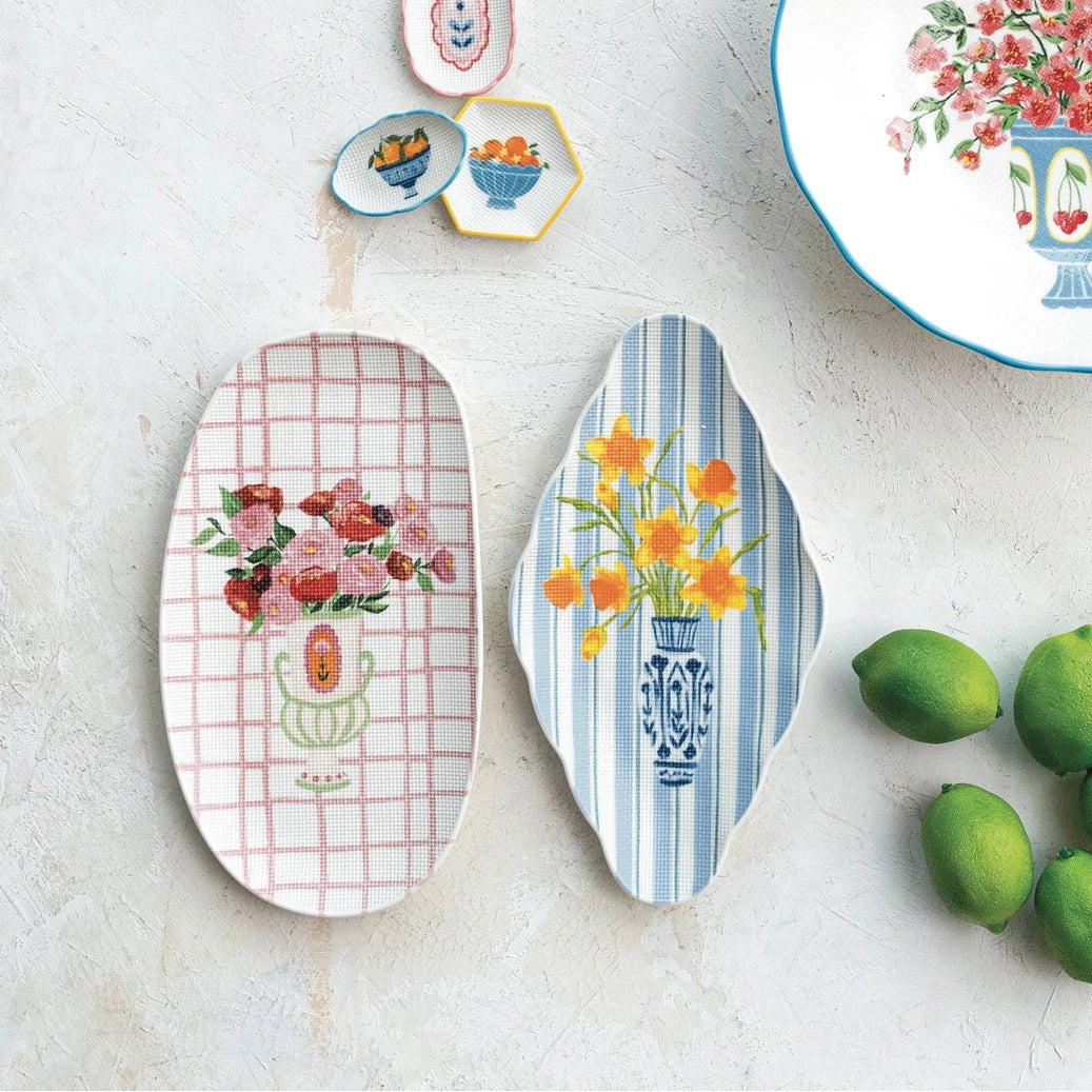 Decorative plates with floral designs on a white surface with limes.
