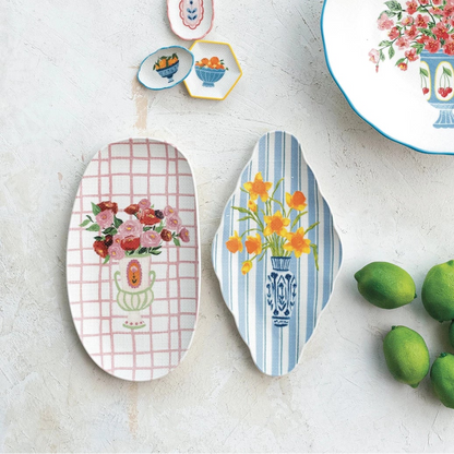 Decorative plates with floral designs on a white surface with limes.