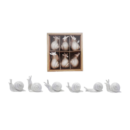 6 ceramic snails in a row with another 6 snails in a box, shown on a white background