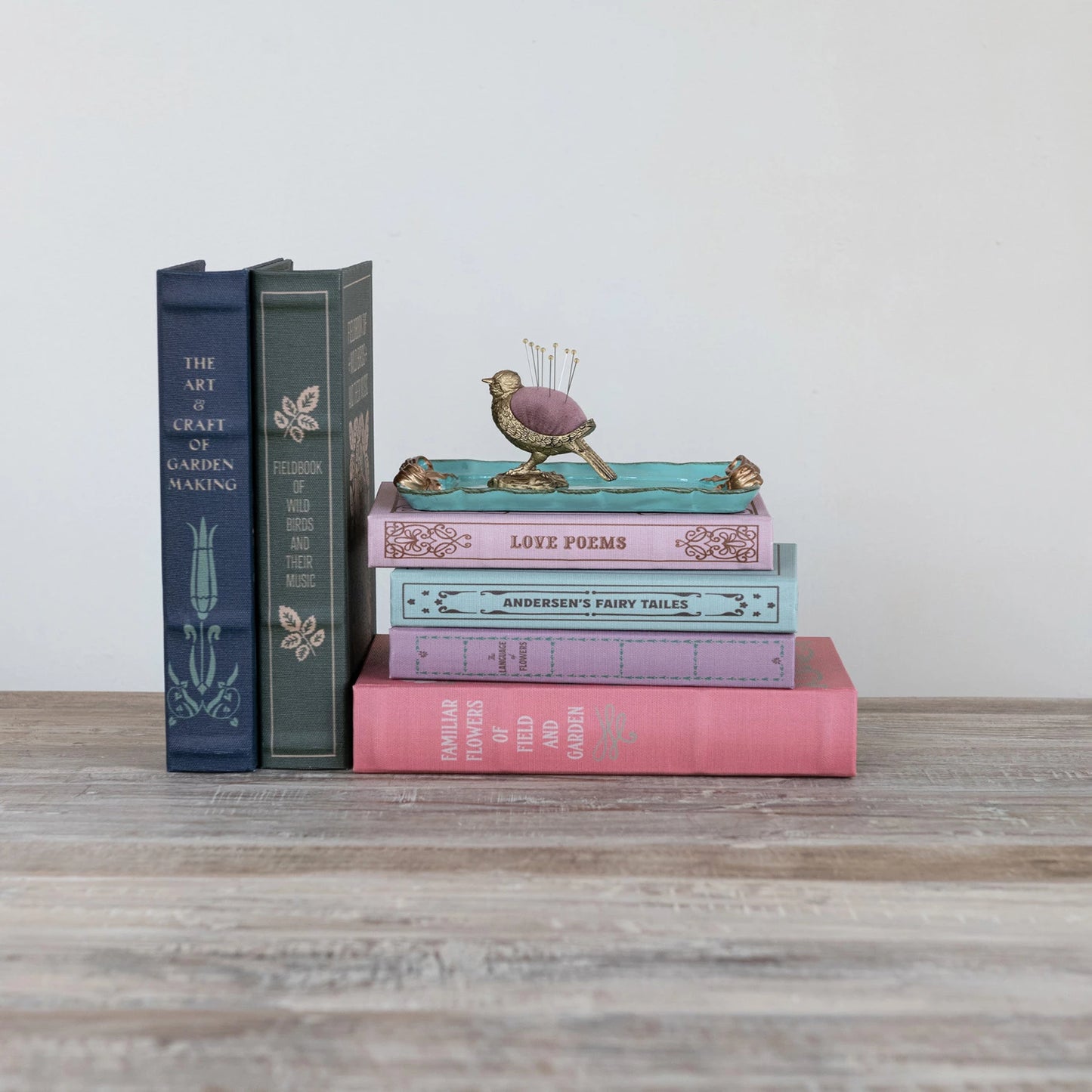 assorted book boxes stacked with a little bird perched on them