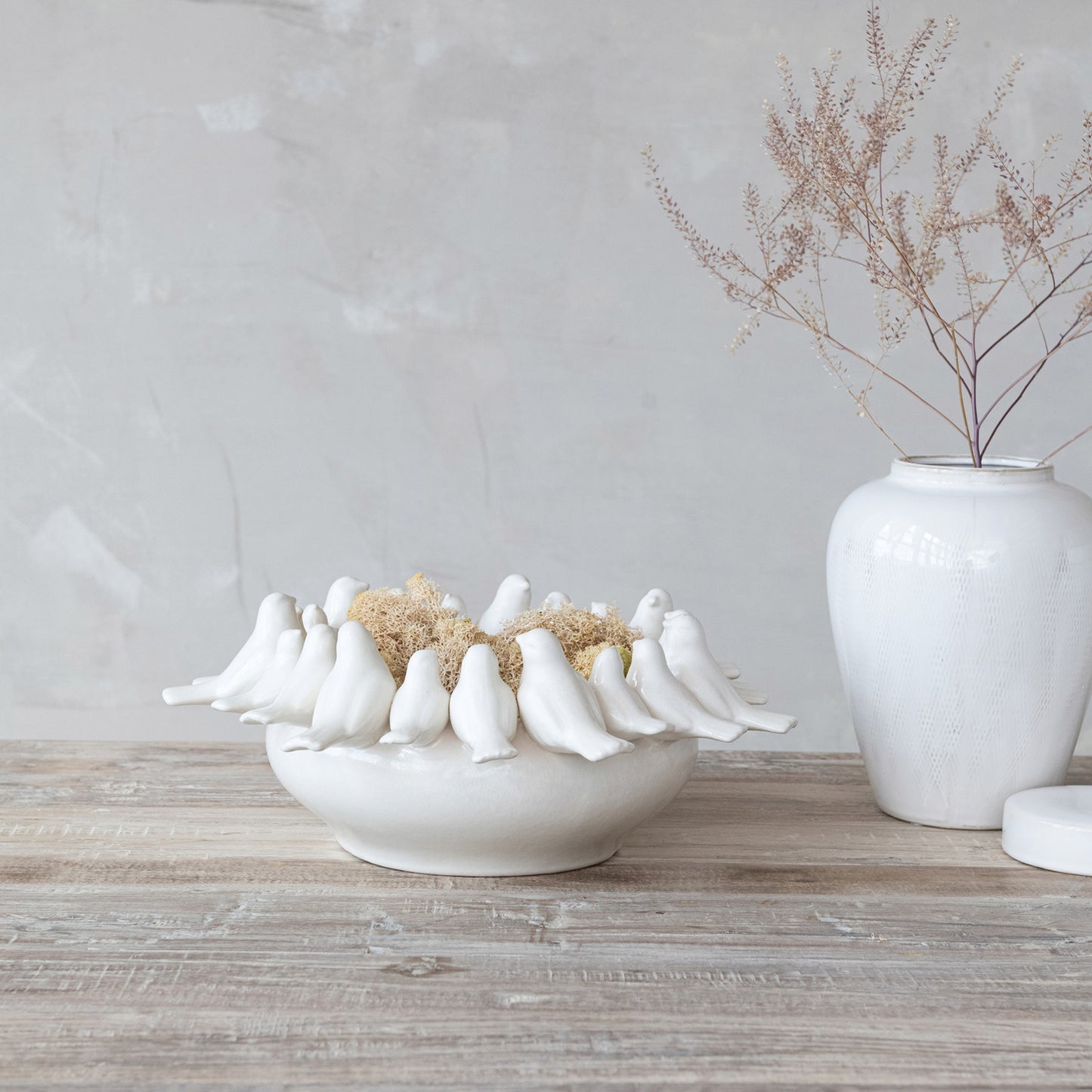 white planter with white birds on rim in a decorated setting