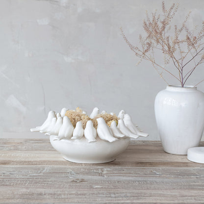 white planter with white birds on rim in a decorated setting