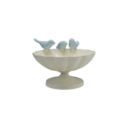 Decorative bowl with three small bird figurines on the rim on a white background