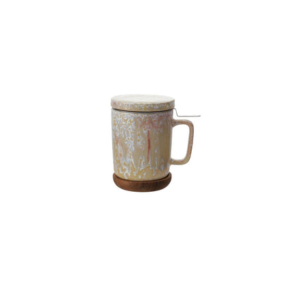 ceramic lidded  beige and pink mug with handle and metal tea strainer, on a plain white background.