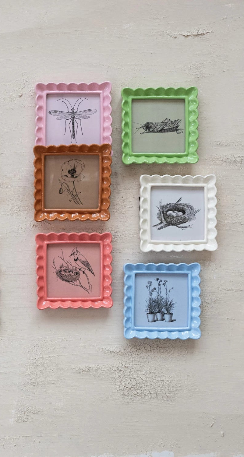 6 photo frames of various colors arranged on a plaster surface