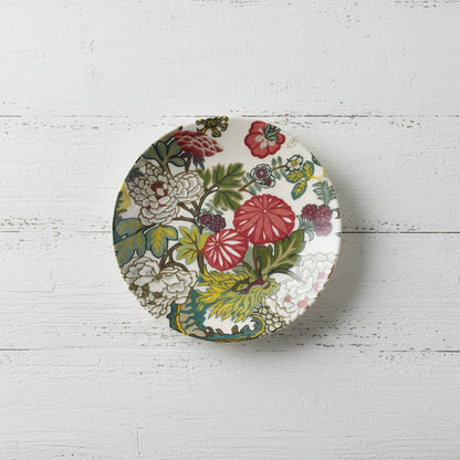 salad plated with colorful floral pattern shown on a white wooden background