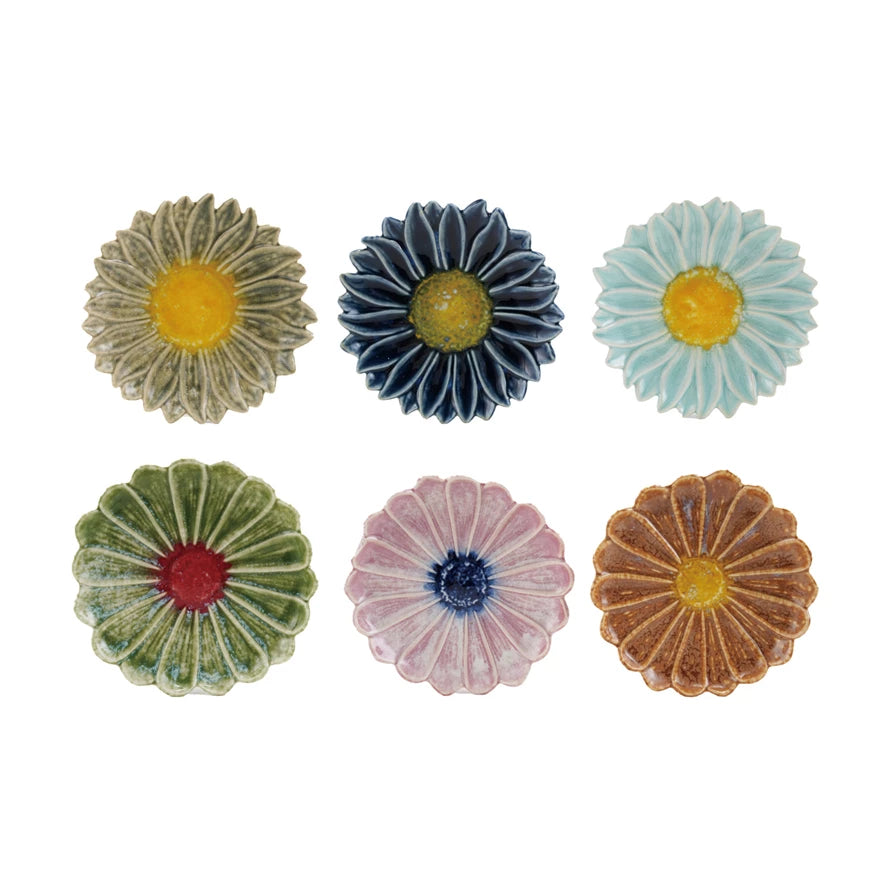 six colorful ceramic flower-shaped plates on a white background