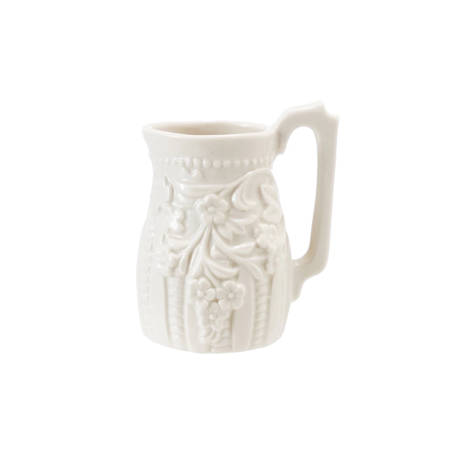 White ceramic creamer pitcher with decorative patterns on a white background