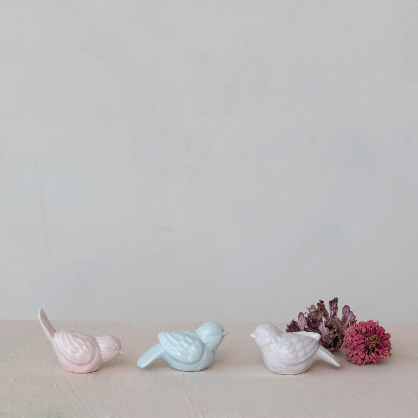 3 bird sitters on a decorated surface